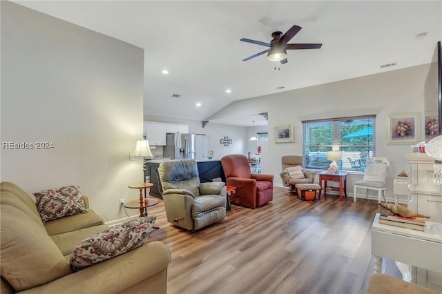 living room featuring lofted ceiling, hardwood / wood-style flooring, and ceiling fan