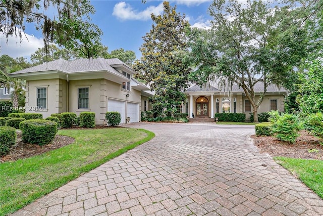 view of front of property featuring a garage and a front lawn