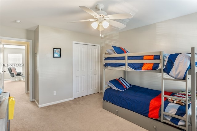 carpeted bedroom featuring ceiling fan and a closet