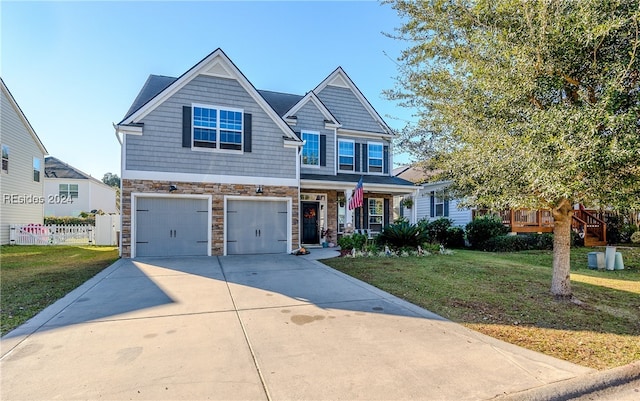 craftsman inspired home featuring a garage and a front lawn