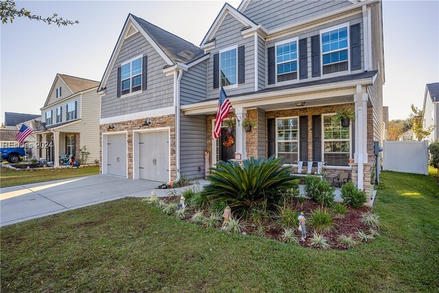 view of front of home with a garage, a front lawn, and a porch