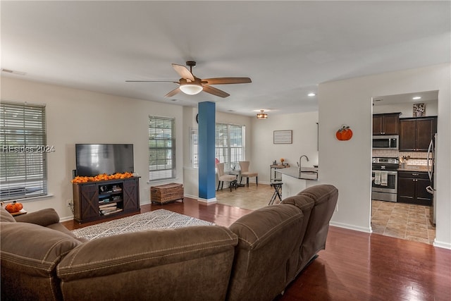 living room with sink, light hardwood / wood-style floors, and ceiling fan