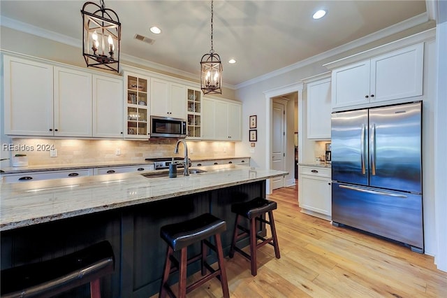 kitchen featuring sink, white cabinets, backsplash, hanging light fixtures, and stainless steel appliances