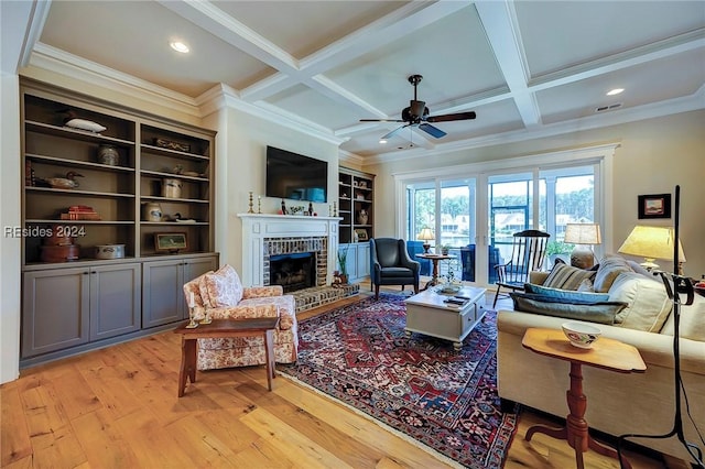 living room featuring coffered ceiling, a brick fireplace, and beamed ceiling