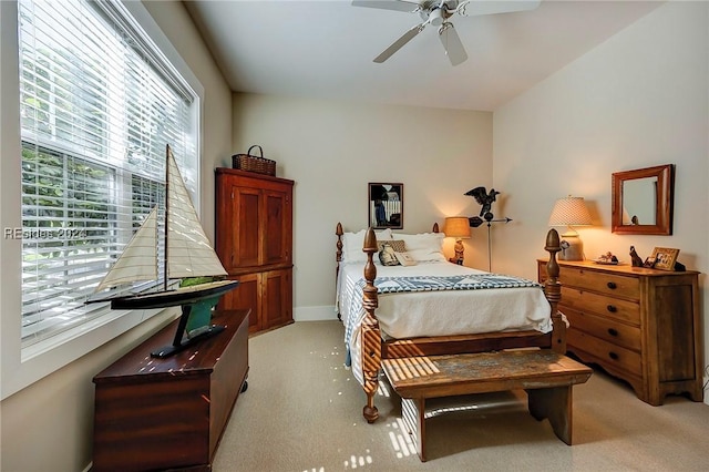 carpeted bedroom with multiple windows and ceiling fan