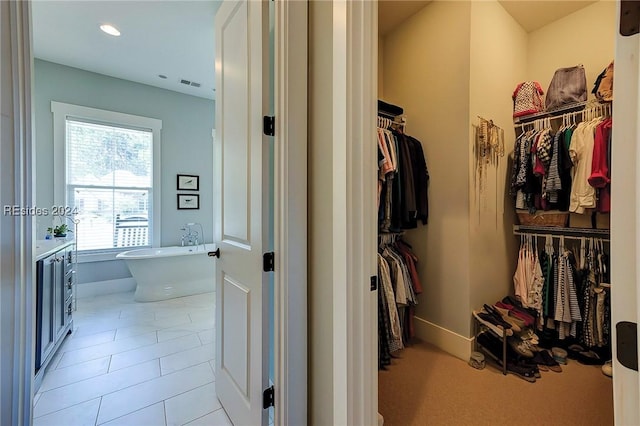 walk in closet with light tile patterned floors