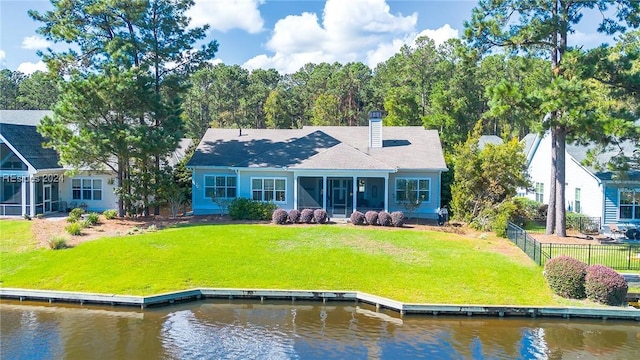 back of house featuring a water view, a yard, and a sunroom