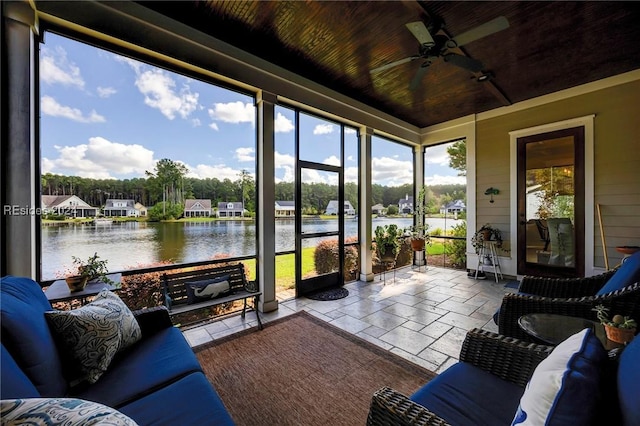 sunroom with wooden ceiling, ceiling fan, and a water view