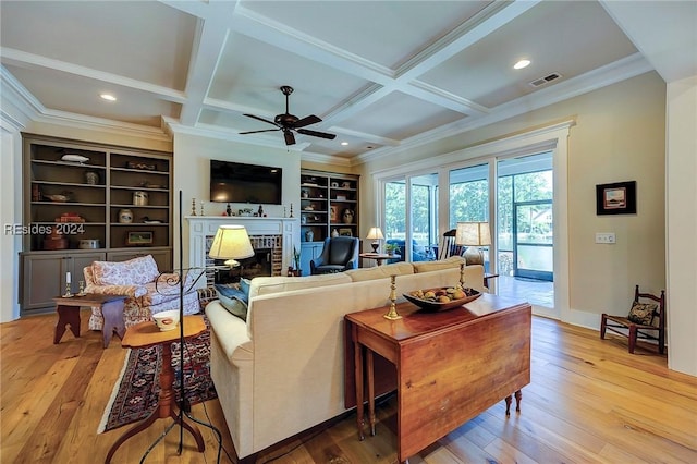 living room with beamed ceiling, coffered ceiling, and light wood-type flooring