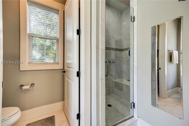 bathroom featuring tile patterned floors, toilet, and a shower with shower door