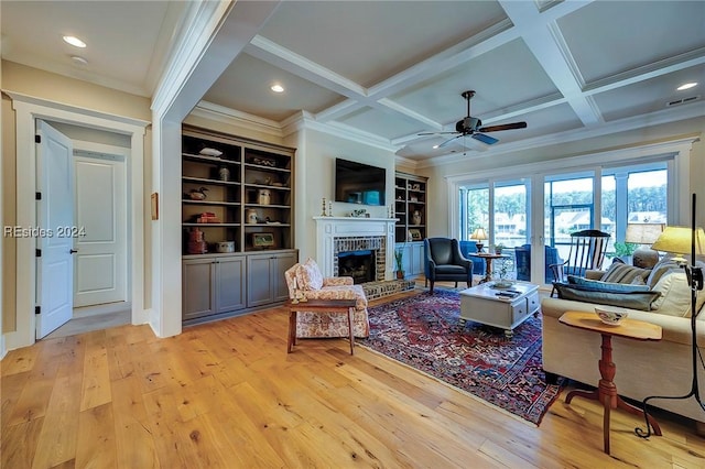 living room featuring coffered ceiling, a fireplace, and beamed ceiling