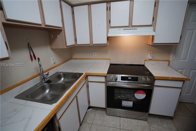 kitchen featuring white cabinetry, light tile patterned floors, sink, and electric range