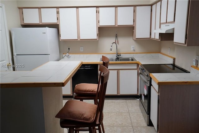 kitchen featuring white fridge, white cabinets, and electric stove