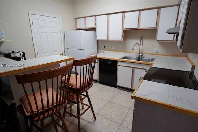 kitchen featuring sink, dishwasher, white cabinetry, light tile patterned flooring, and white fridge