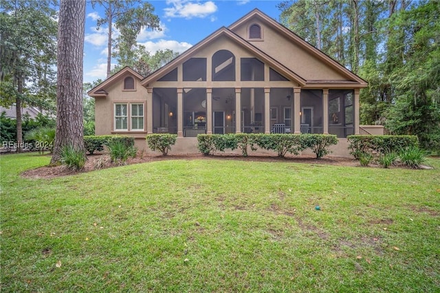 rear view of property with a sunroom and a lawn