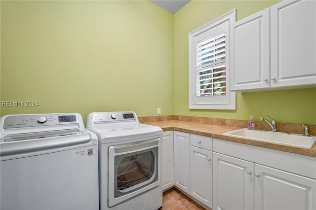 laundry room featuring cabinets, separate washer and dryer, sink, and light tile patterned floors