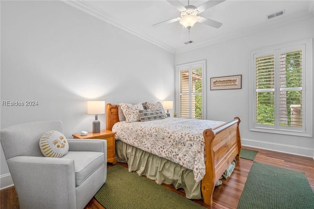 bedroom featuring dark wood-type flooring, ceiling fan, and ornamental molding