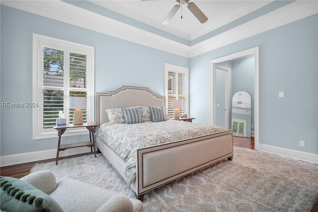 bedroom with wood-type flooring, crown molding, and ceiling fan