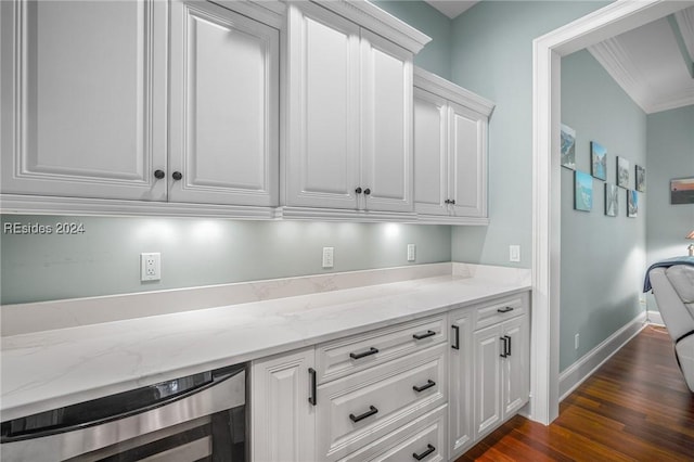 interior space with wine cooler, crown molding, light stone counters, dark hardwood / wood-style flooring, and white cabinets