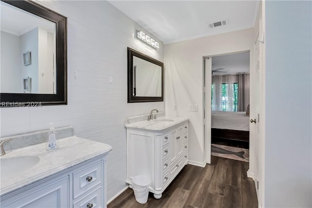 bathroom with wood-type flooring, ornamental molding, tile walls, and vanity