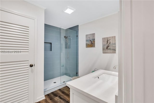 bathroom with hardwood / wood-style flooring, vanity, and walk in shower