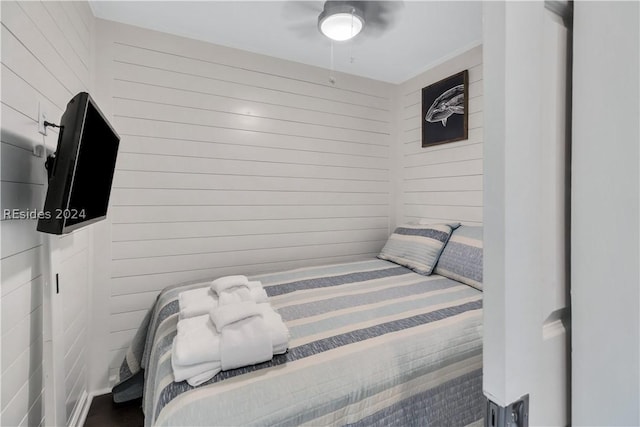 bedroom featuring wooden walls