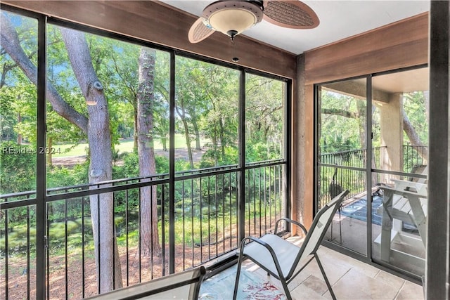 unfurnished sunroom with ceiling fan