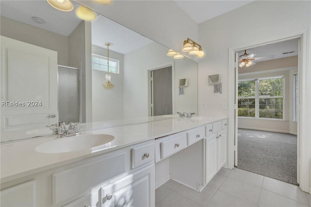 bathroom featuring tile patterned flooring, vanity, plenty of natural light, and walk in shower