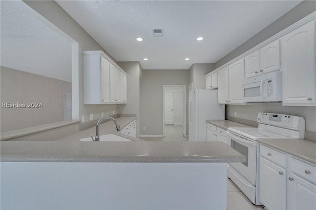 kitchen with white cabinetry, sink, white appliances, and kitchen peninsula