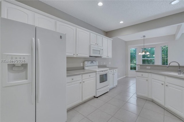 kitchen featuring sink, white appliances, hanging light fixtures, a textured ceiling, and white cabinets