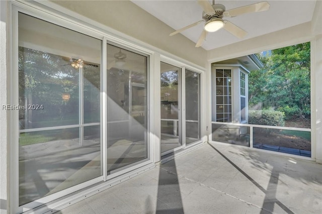 unfurnished sunroom featuring ceiling fan