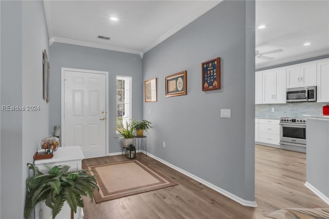 entryway with crown molding, ceiling fan, and light hardwood / wood-style flooring