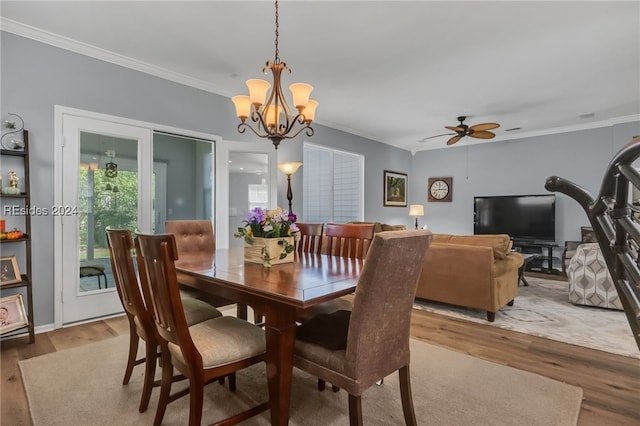 dining area with ceiling fan with notable chandelier, ornamental molding, and hardwood / wood-style floors