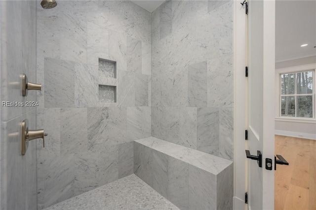 bathroom with crown molding and tiled shower