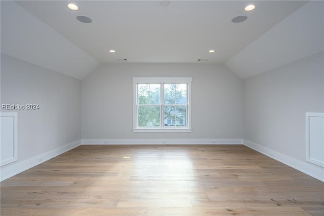 bonus room with vaulted ceiling and light wood-type flooring