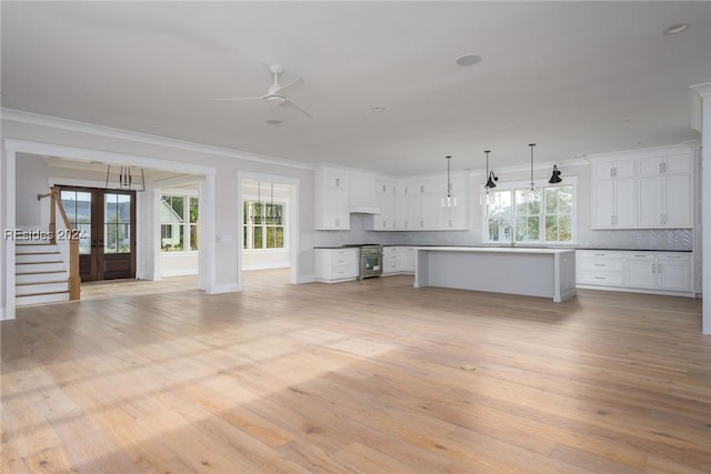 unfurnished living room with crown molding, ceiling fan, sink, and light hardwood / wood-style flooring