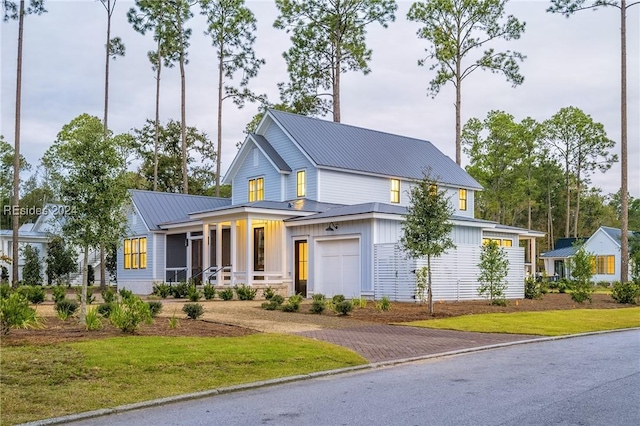 view of front of property featuring a garage, a front yard, and covered porch