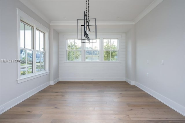 unfurnished dining area featuring crown molding, plenty of natural light, and light hardwood / wood-style floors