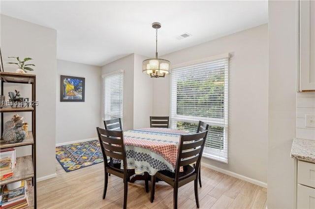 dining room featuring plenty of natural light, light hardwood / wood-style floors, and a chandelier