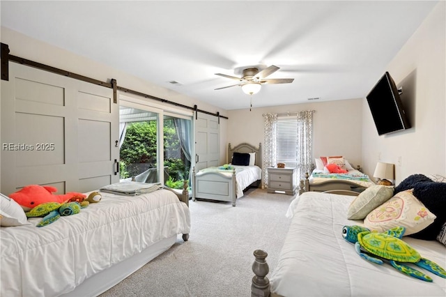 bedroom featuring a barn door, light carpet, access to exterior, and ceiling fan