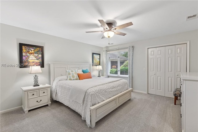 bedroom featuring ceiling fan, light colored carpet, and a closet