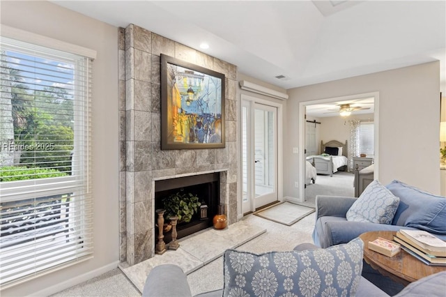 carpeted living room with a tile fireplace and a wealth of natural light