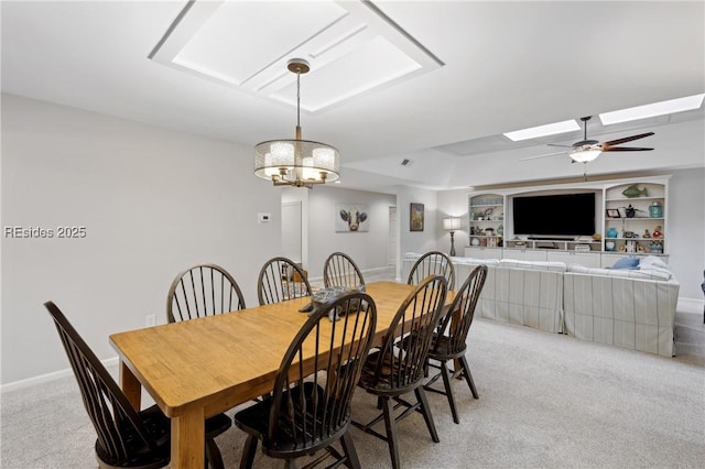 carpeted dining room featuring a skylight, built in features, and ceiling fan