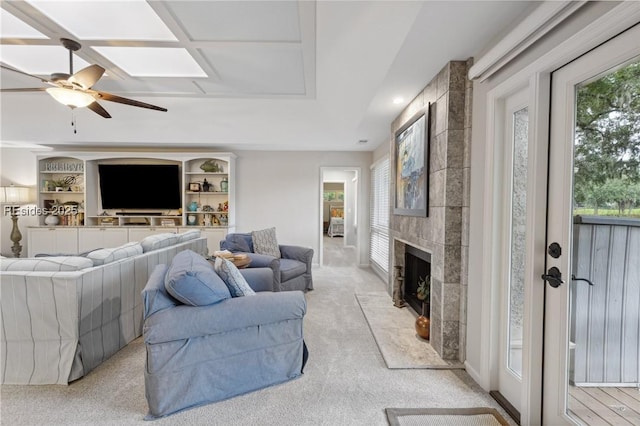 living room with light carpet, ceiling fan, a fireplace, and a healthy amount of sunlight