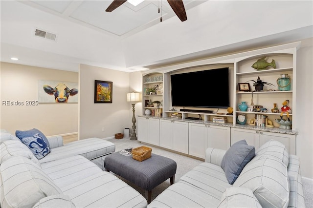 carpeted living room featuring ceiling fan and built in shelves