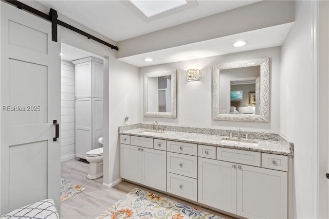 bathroom featuring hardwood / wood-style flooring, vanity, and toilet