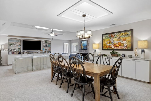 dining space featuring light carpet, built in features, and ceiling fan