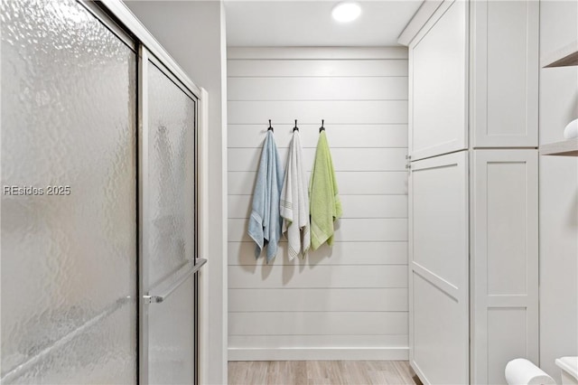 mudroom featuring wood walls and light wood-type flooring