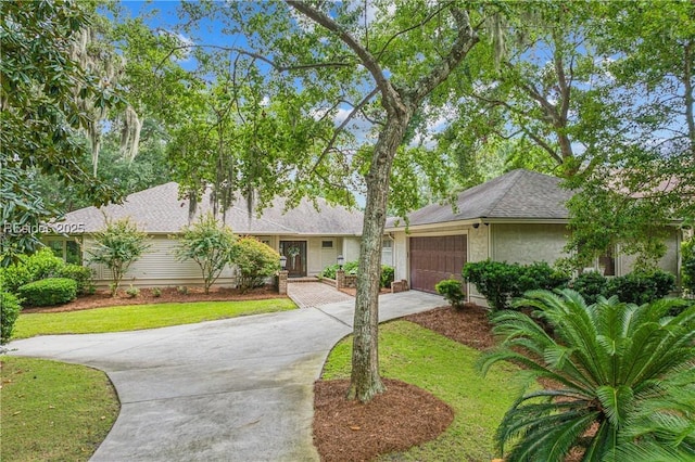 ranch-style house featuring a garage and a front lawn