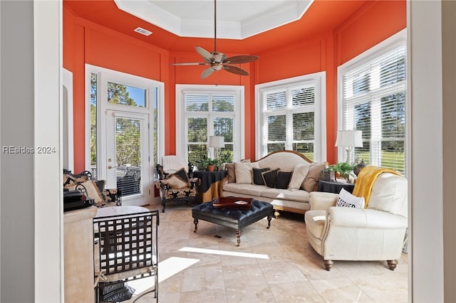 sunroom / solarium with a raised ceiling and ceiling fan